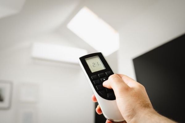 Man holding air conditioning remote 600 Pexels