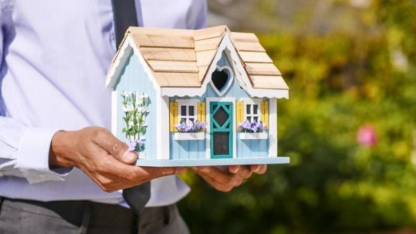 Person holding a miniature decorative house 600 Pexels