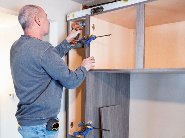 Man installing garage cabinet 600 Canva