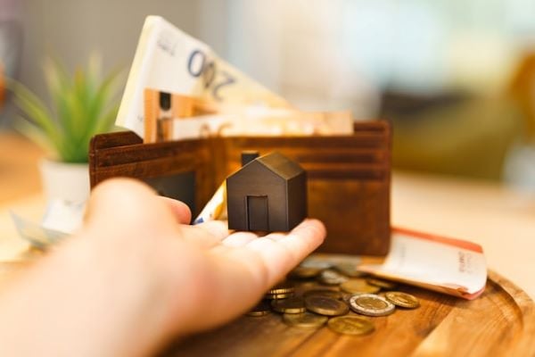 Person holding a small house and money 600 Unsplash 