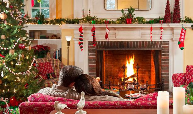 couple on couch in front of the fireplace on Christmas